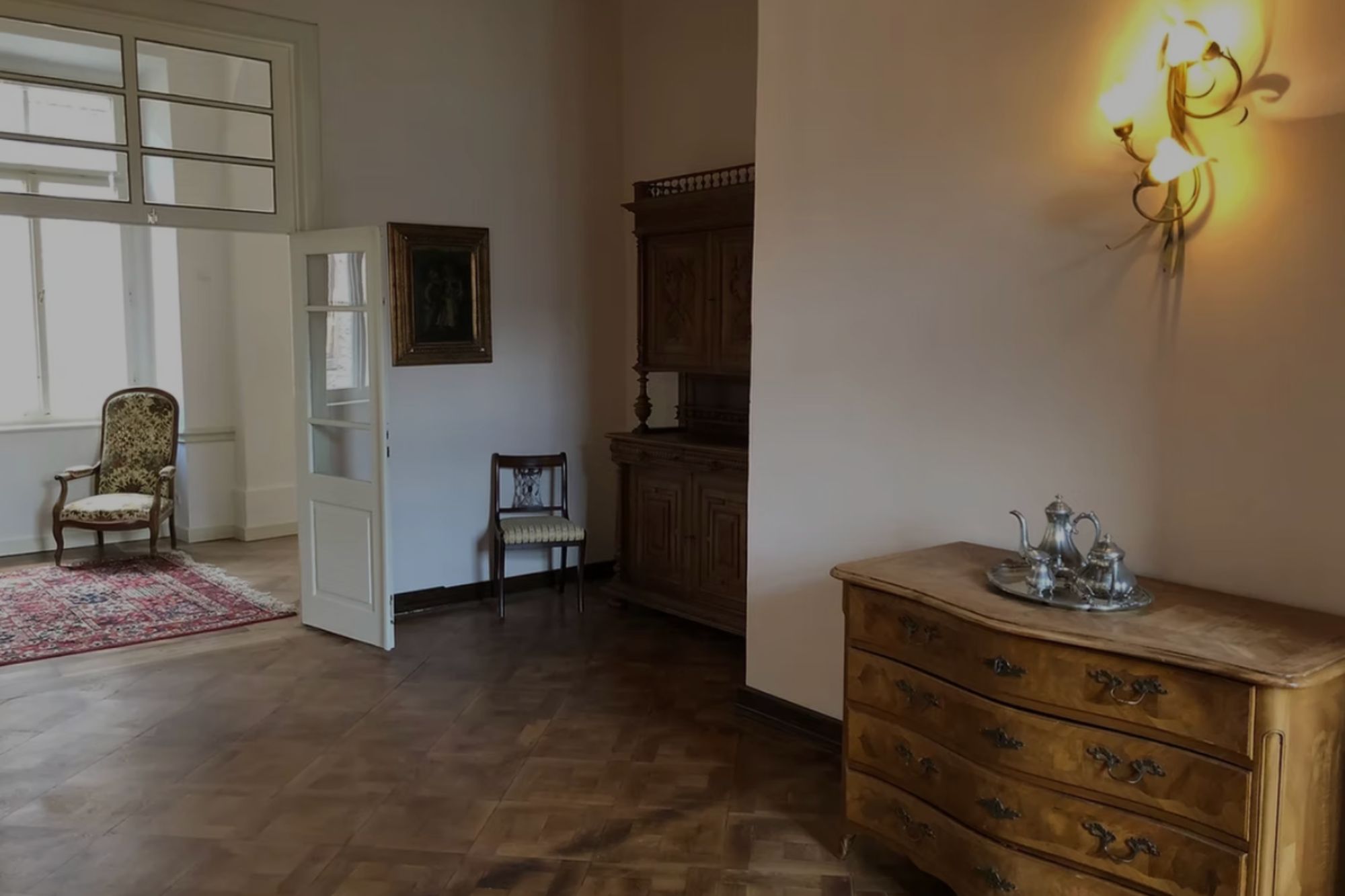 Historischer Innenraum von Schloss Gleina mit Holzboden, antiken Möbeln, geöffneten Flügeltüren und warmem Licht im Barockstil.