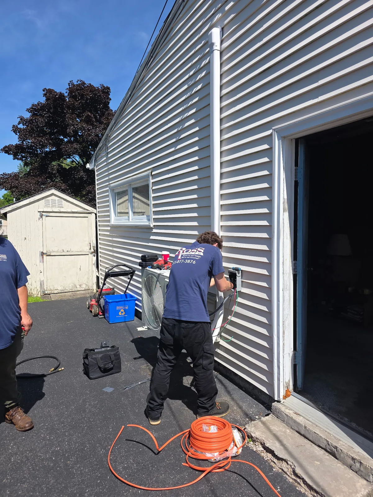 Ross technician working beside outdoor HVAC equipment