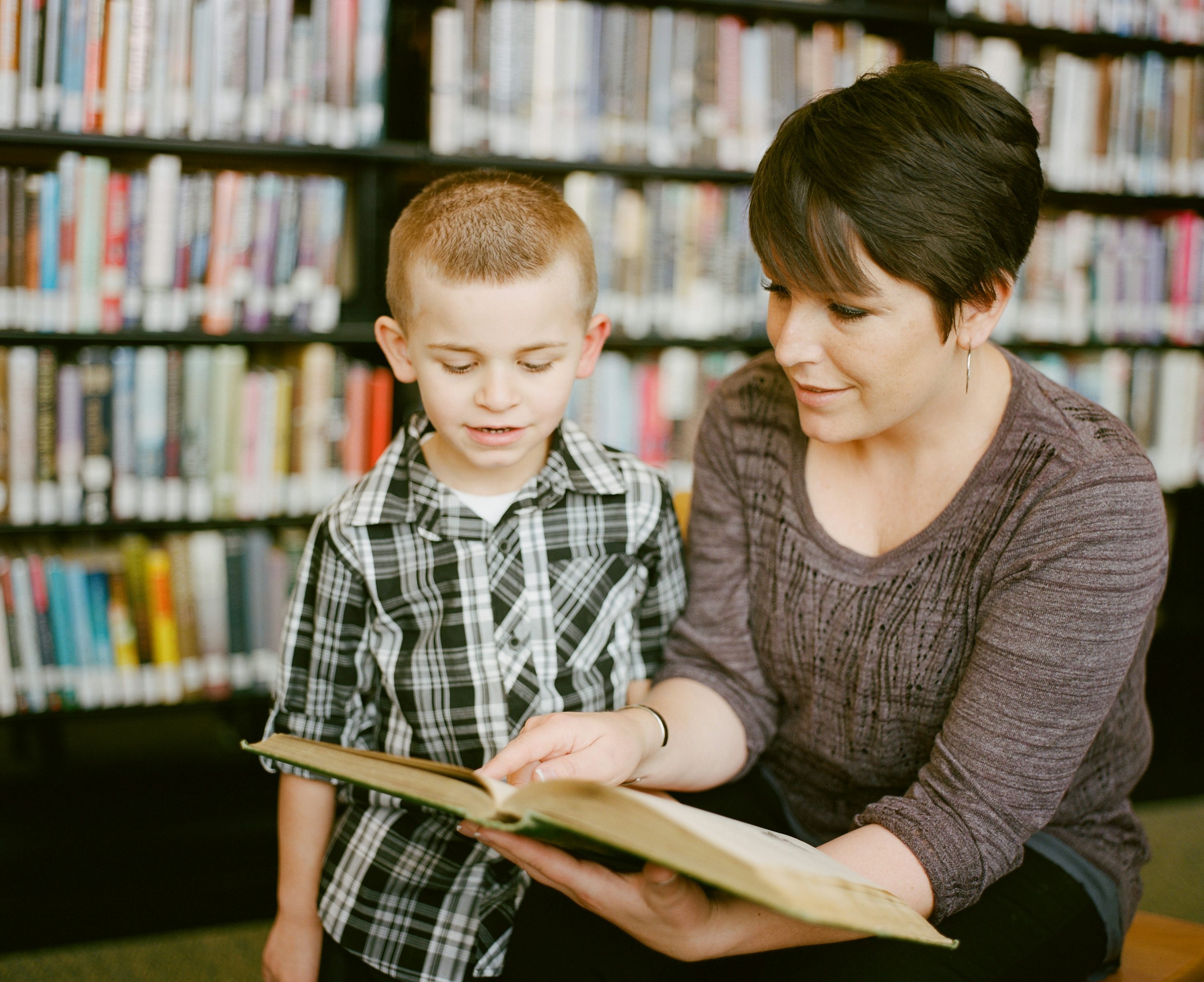 Adult reading with a child in a library