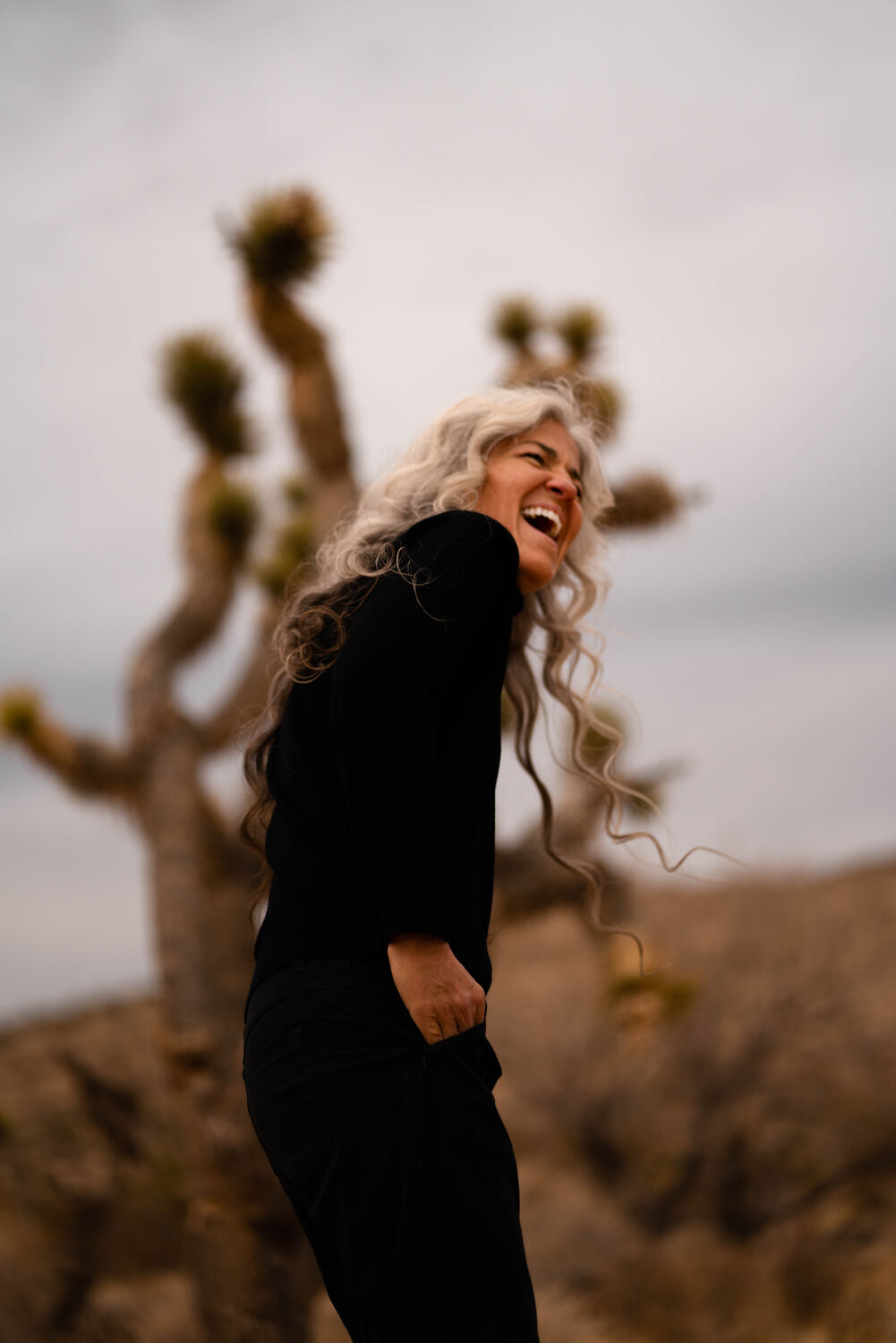 Jennifer Flynn laughing in the desert near a Joshua tree