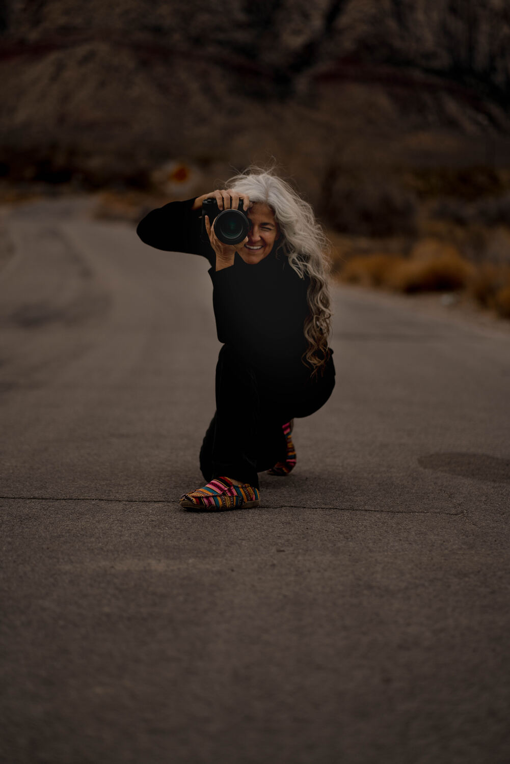 Jennifer Flynn crouched, camera raised, candid moment
