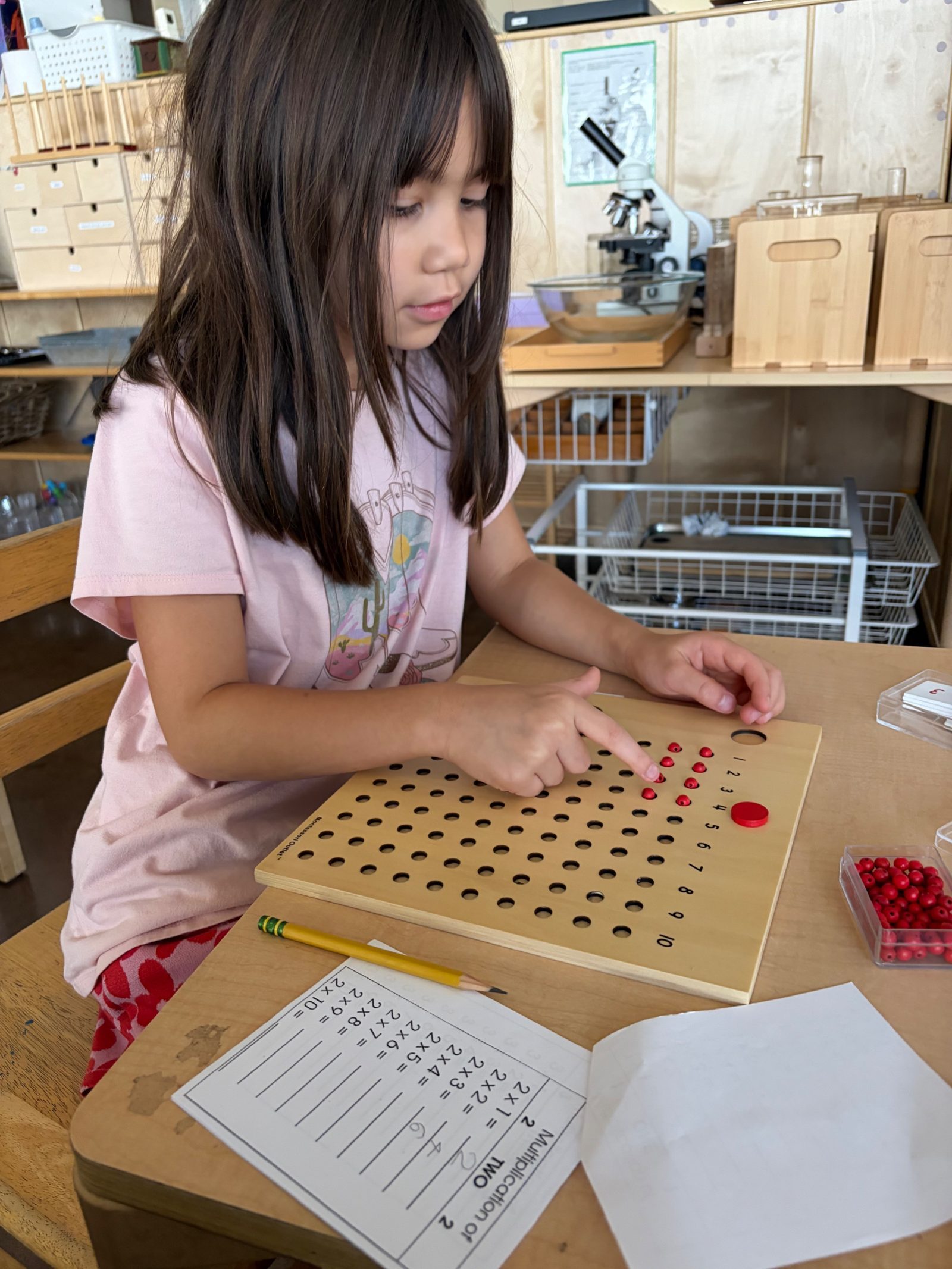 A student using the red bead multiplication board