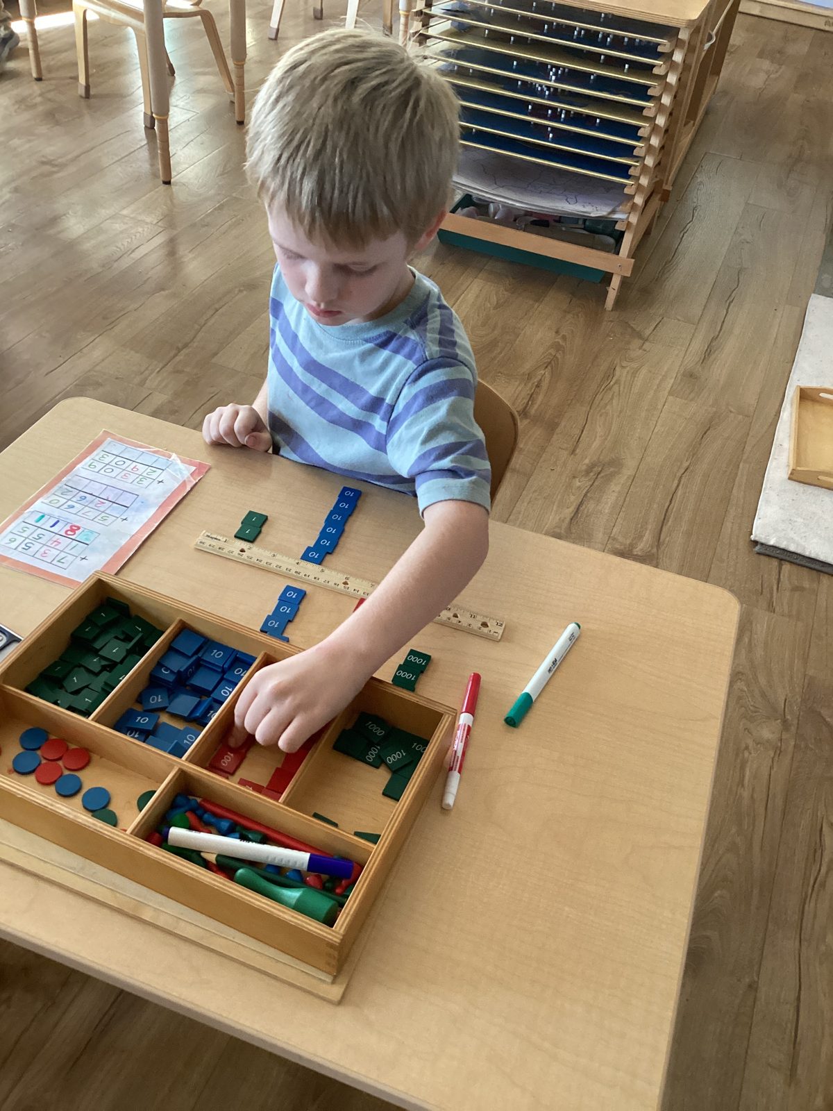A St. Peter's child working with Montessori materials at a table