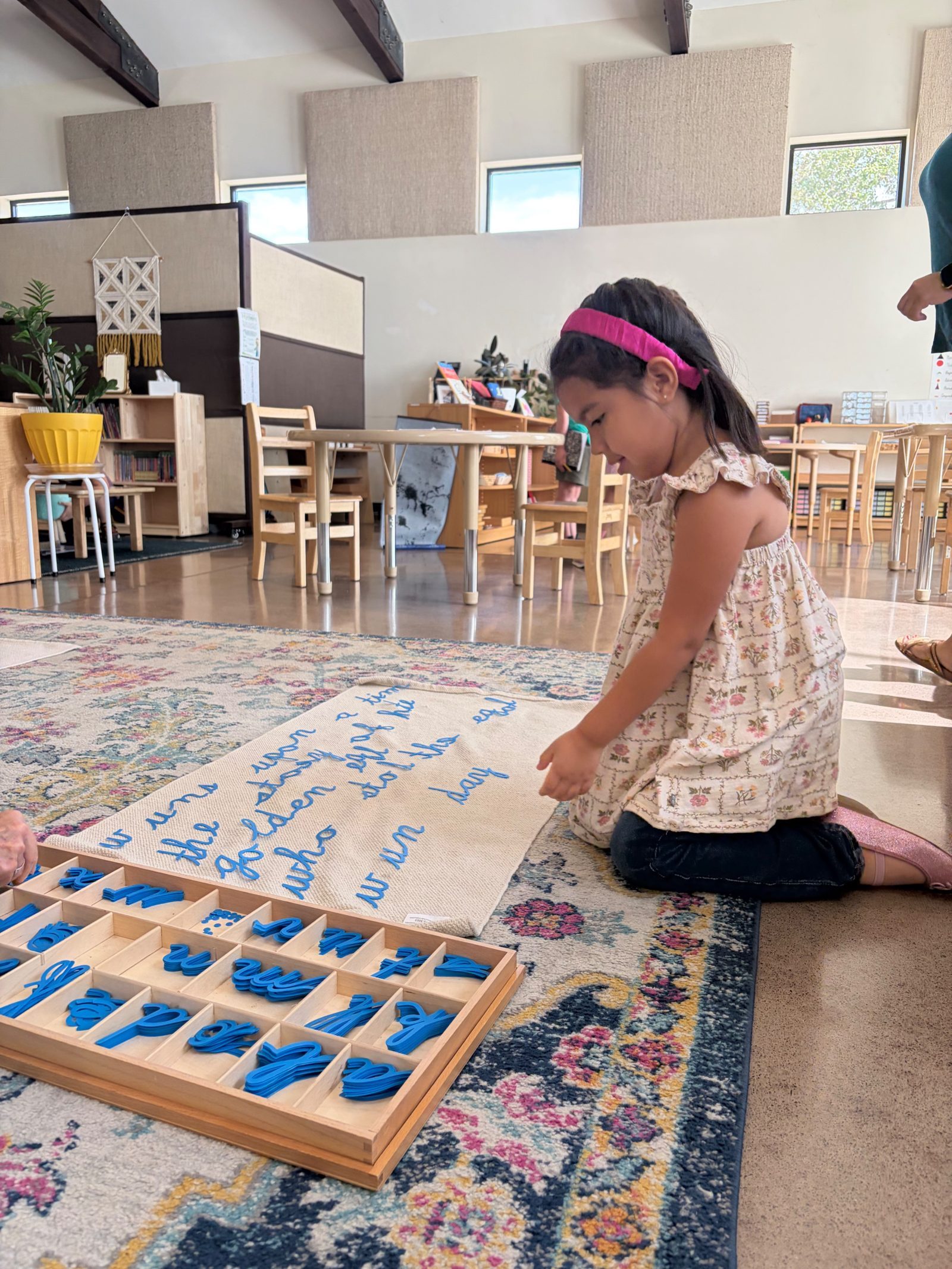 A student building a cursive sentence with the moveable alphabet