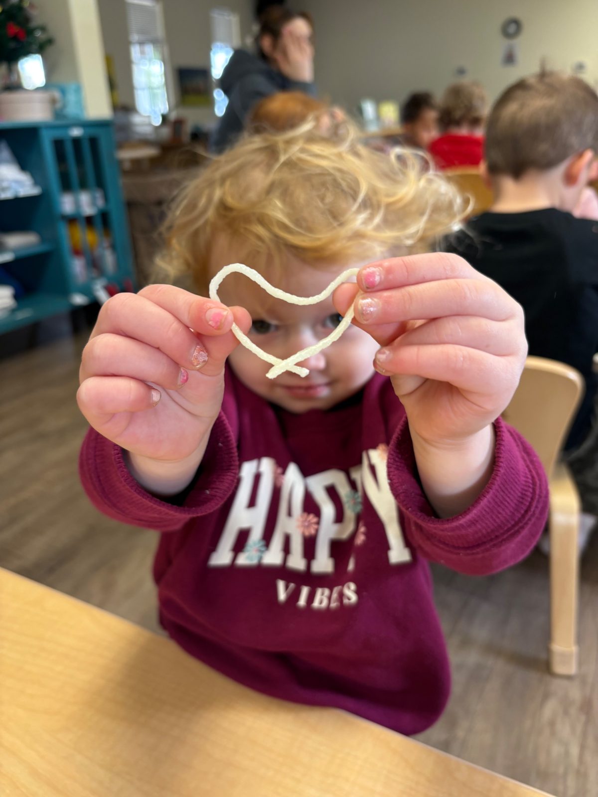 A St. Peter's toddler holding a heart made during class