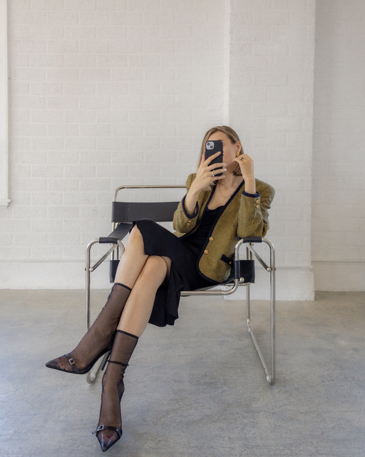 A woman sitting in a chair with a phone near her face. A woman sitting in a chair with a phone near her face.