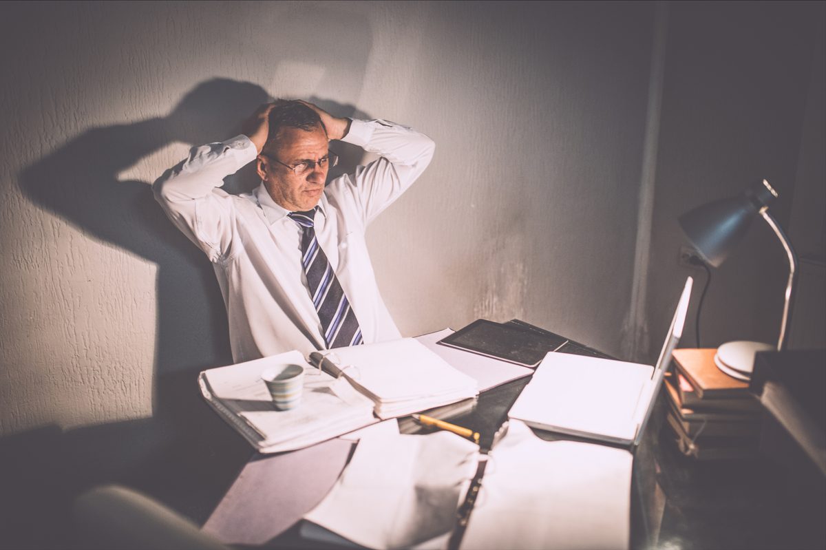 Someone at a desk late at night, head in hands