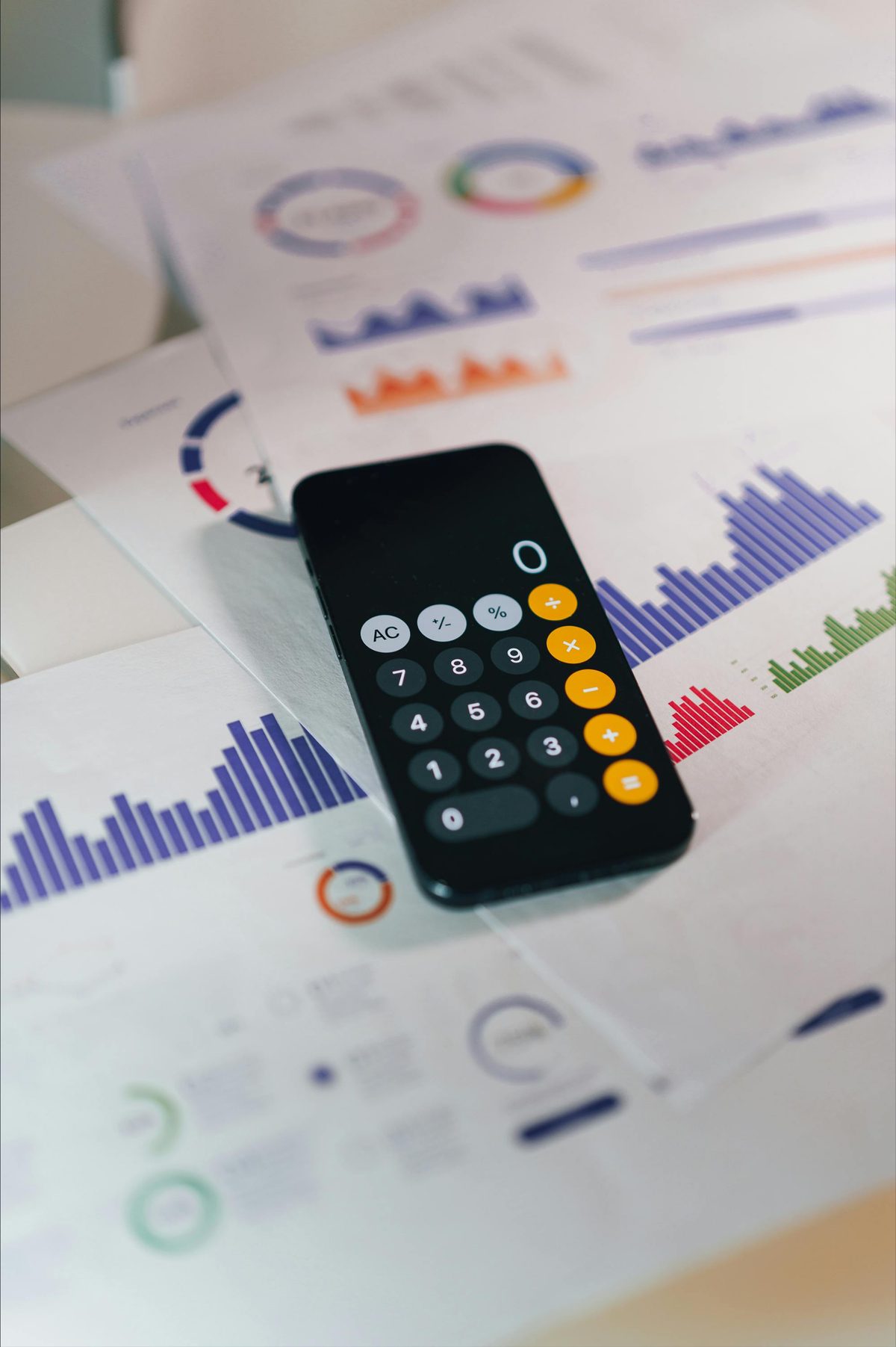 A calculator resting on printed performance charts