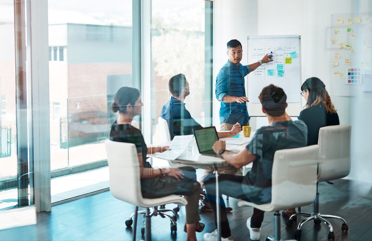 A team meeting around a whiteboard