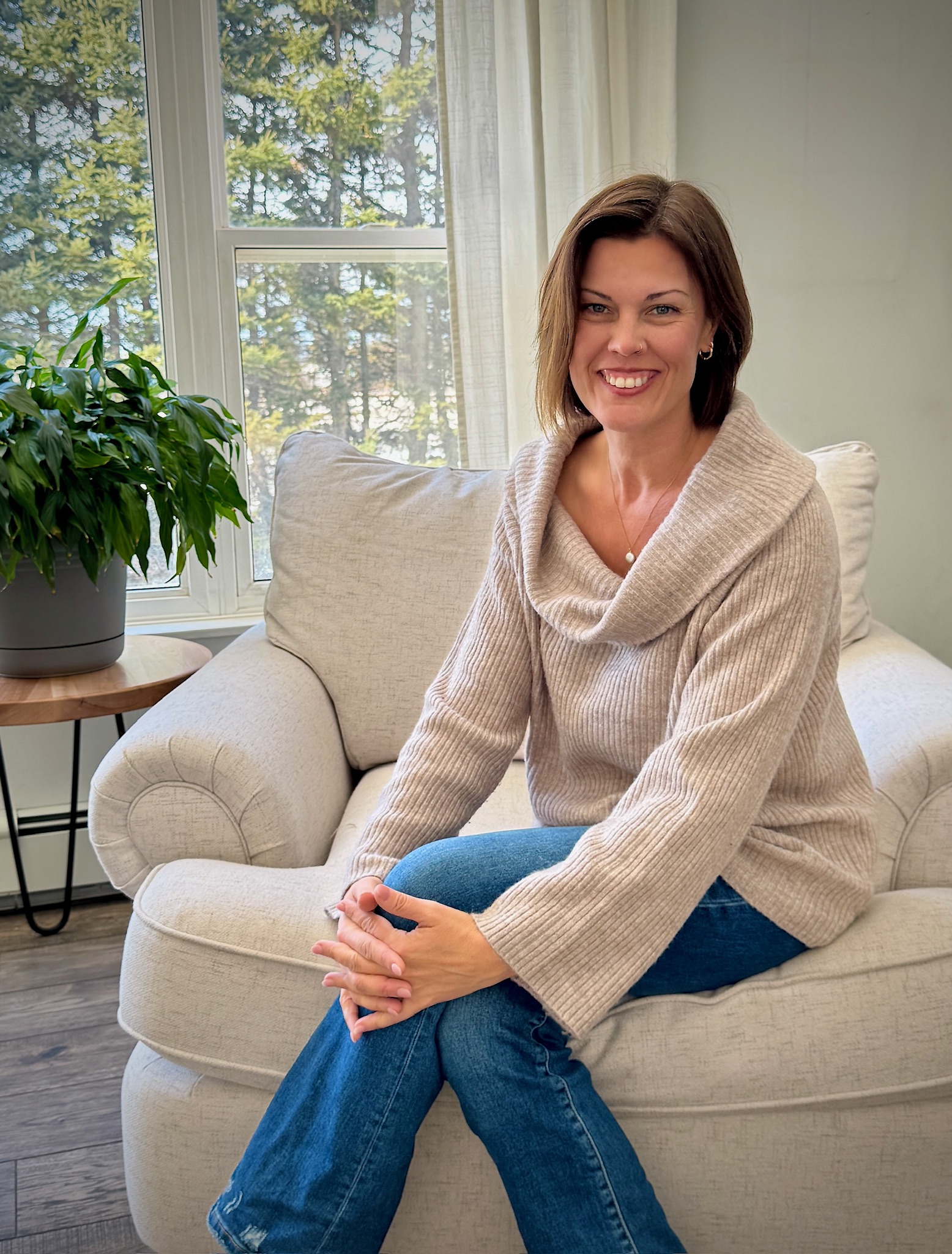 Sarah Carpenter seated in a soft sweater by a bright window