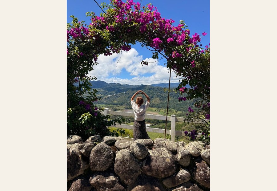 Sarah among garden blooms with arms open