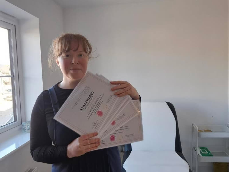 Nicole holding her certificates of achievement