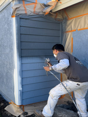 A freshly painted single-story stucco home in San Diego with clean white exterior walls and crisp trim detail. The finished surface shows no peeling or fading under bright coastal sunlight.