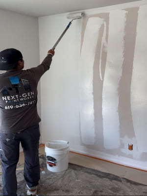A freshly painted interior living room in a San Diego home showing smooth, even walls in a neutral tone with clean trim edges and natural light from a west-facing window. Next-Gen Paintworks completed the interior painting project including walls, ceiling, and door trim.