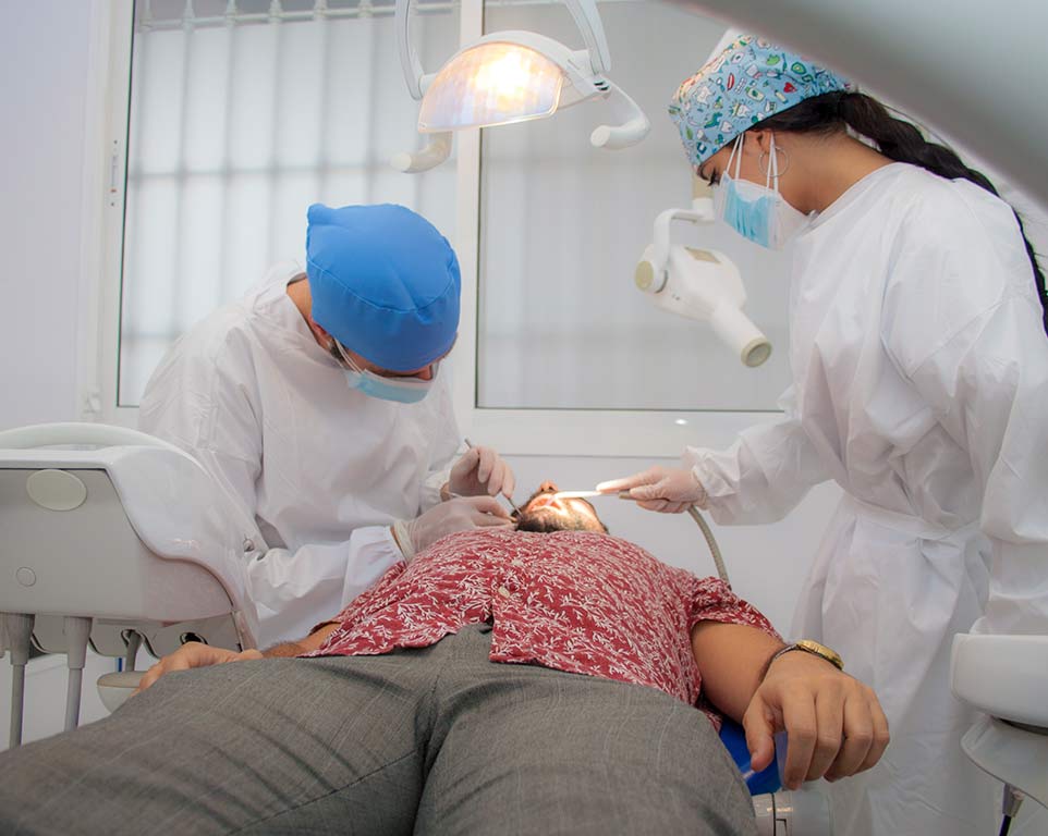 El Dr. Barranco y su equipo atendiendo a un paciente en Clínica Dental Palma