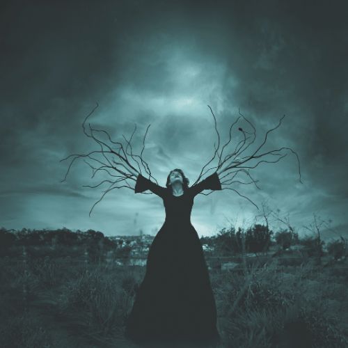 Image of witch standing with her arms spread out and making electricity in the night sky