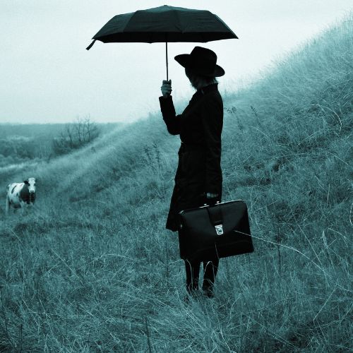 A woman with an umbrella and a briefcase, standing in a field with a cow in the background on a cloudy day