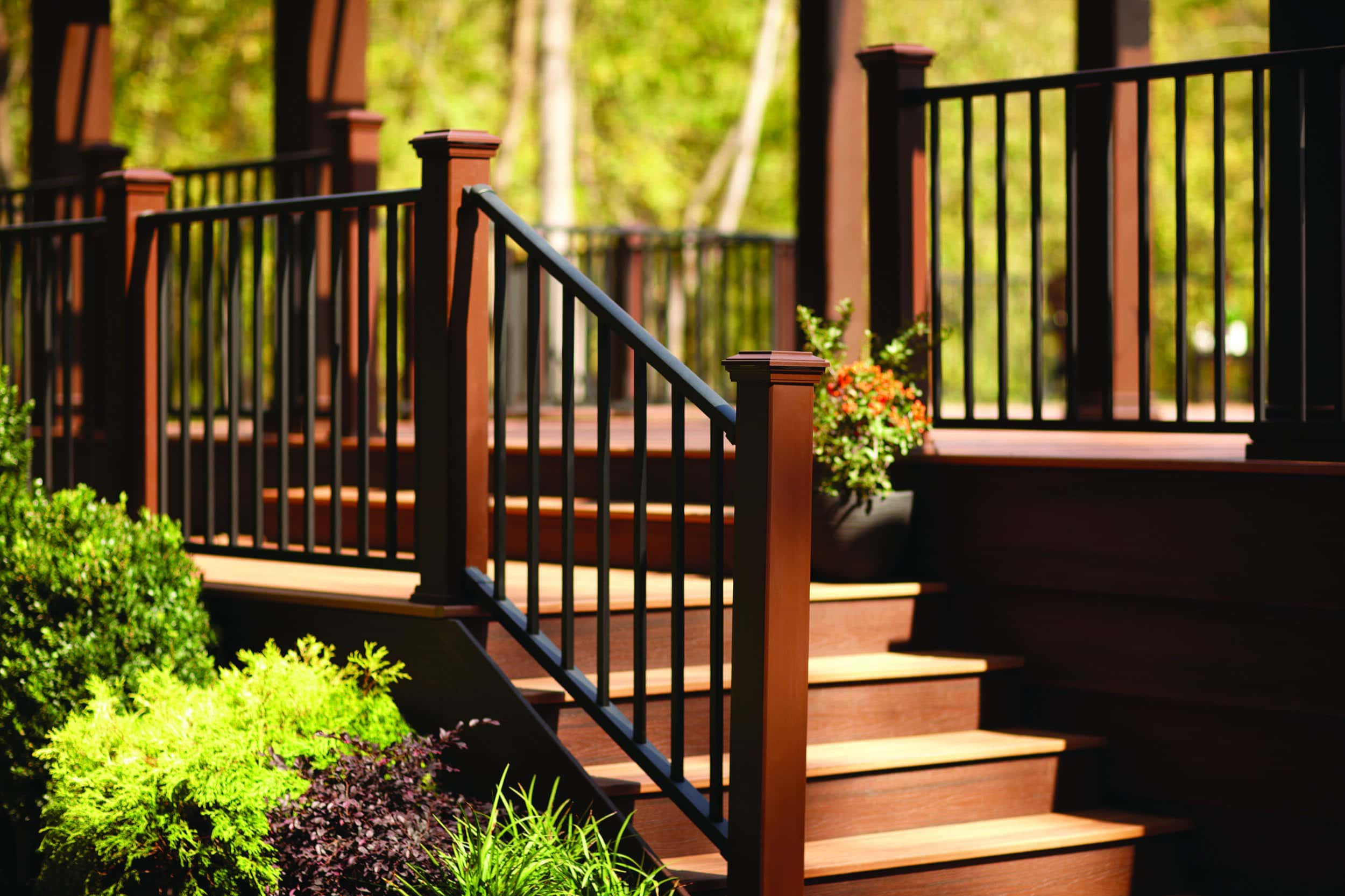 Composite deck railing with black balusters and wooden stairs in a modern outdoor deck design in Pennsylvania Composite deck railing with black balusters and wooden stairs in a modern outdoor deck design in Pennsylvania