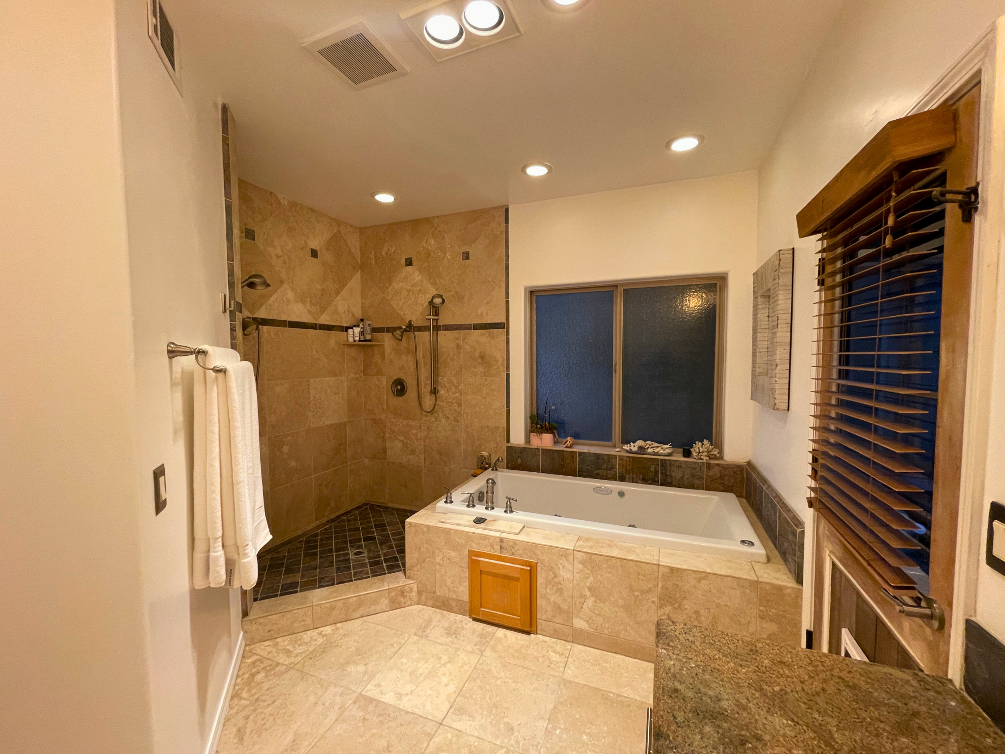 Primary bath with travertine, slate, and a travertine encased jetted tub