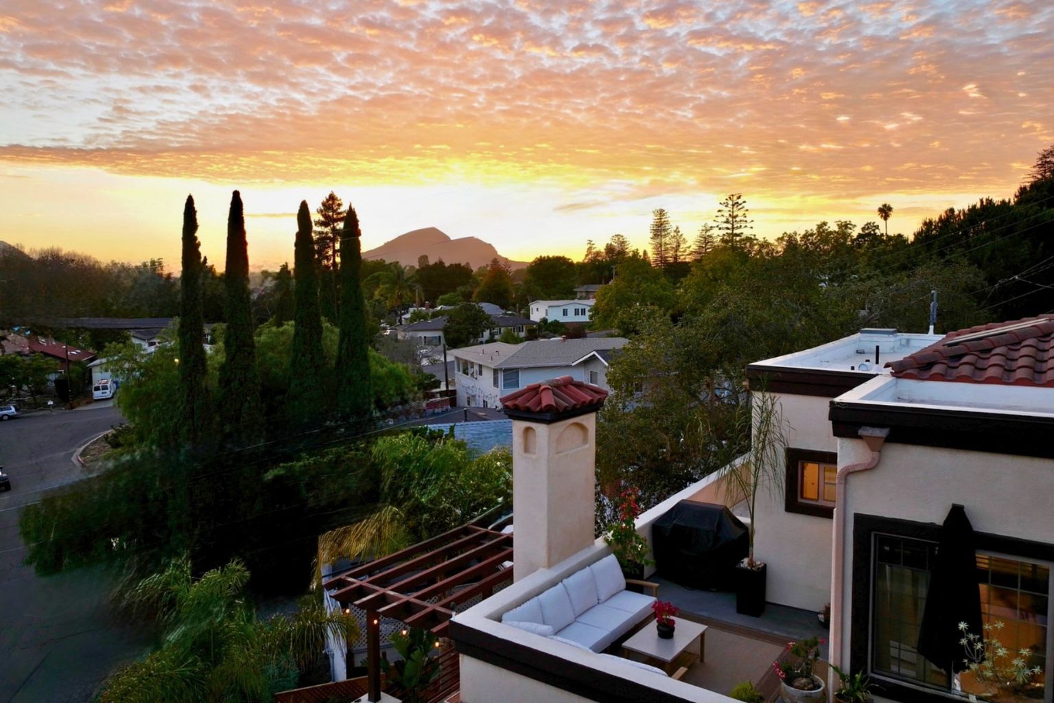Outdoor living environment at 2176 Santa Ynez Avenue with slate terrace, timber pergola, and Mediterranean landscaping