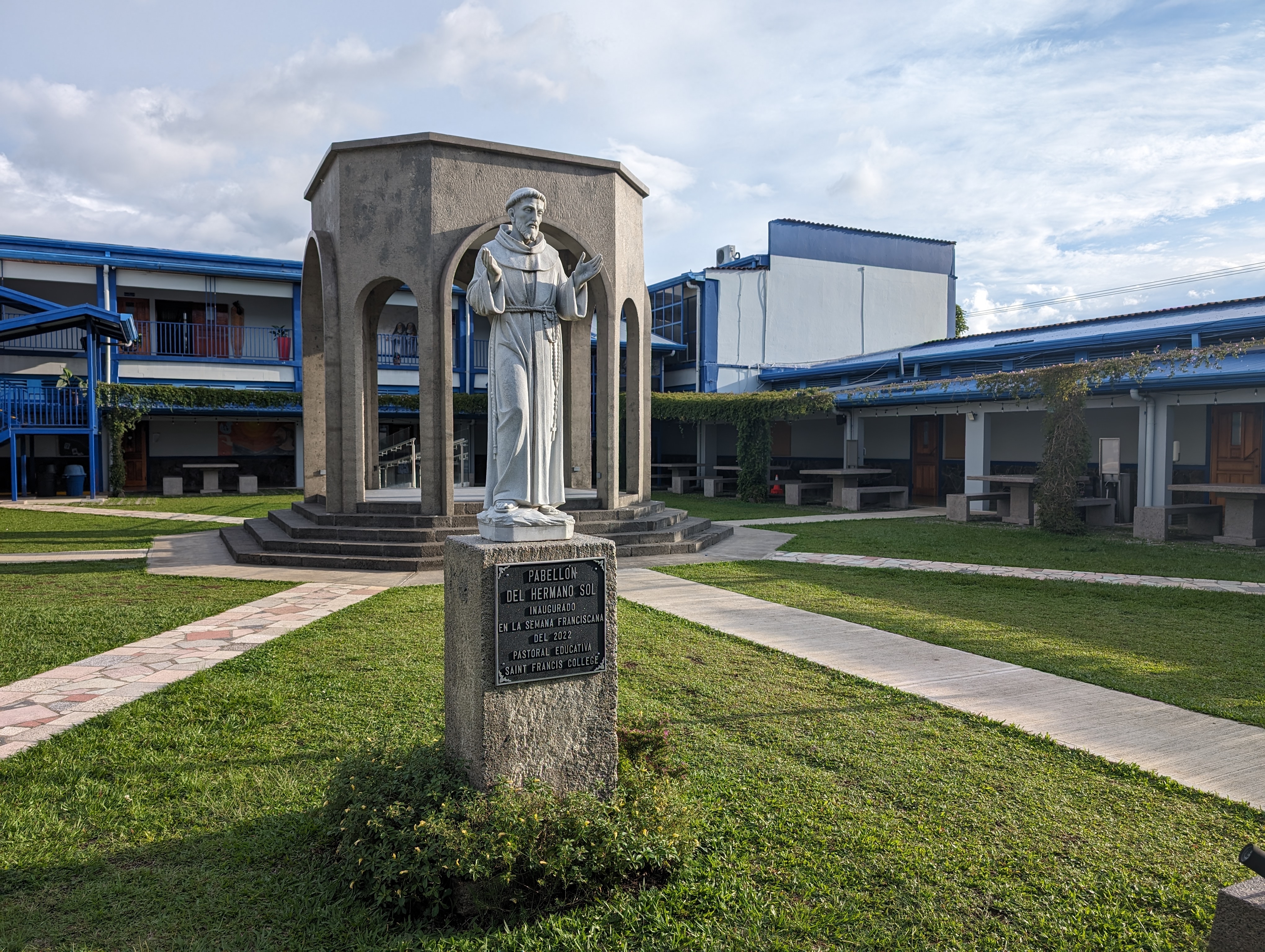 Estatua de un fraile franciscano frente al Pabellón del Hermano Sol, en el patio de Saint Francis College