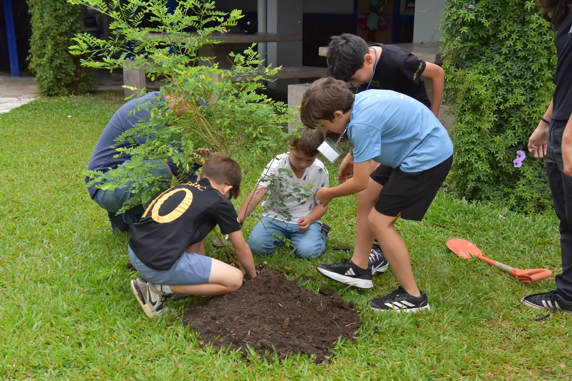 Estudiantes siembran un árbol en el campus como parte del cuidado de la Casa Común