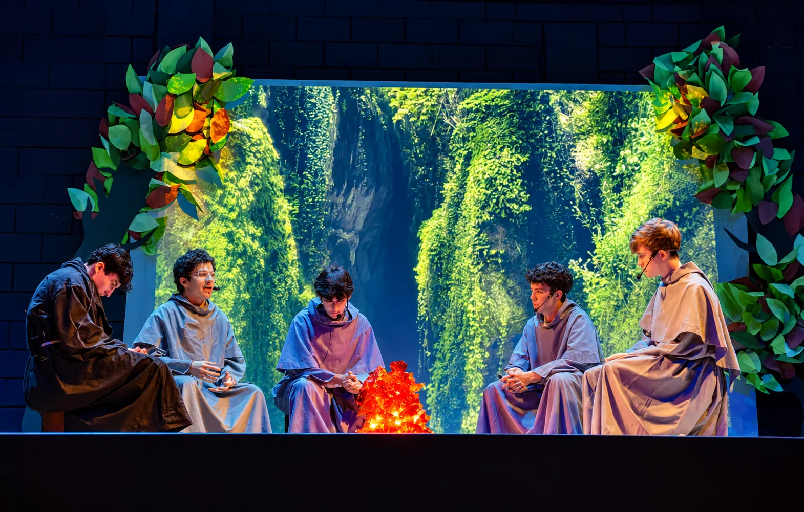 Estudiantes representan a jóvenes franciscanos alrededor del fuego en una obra de teatro