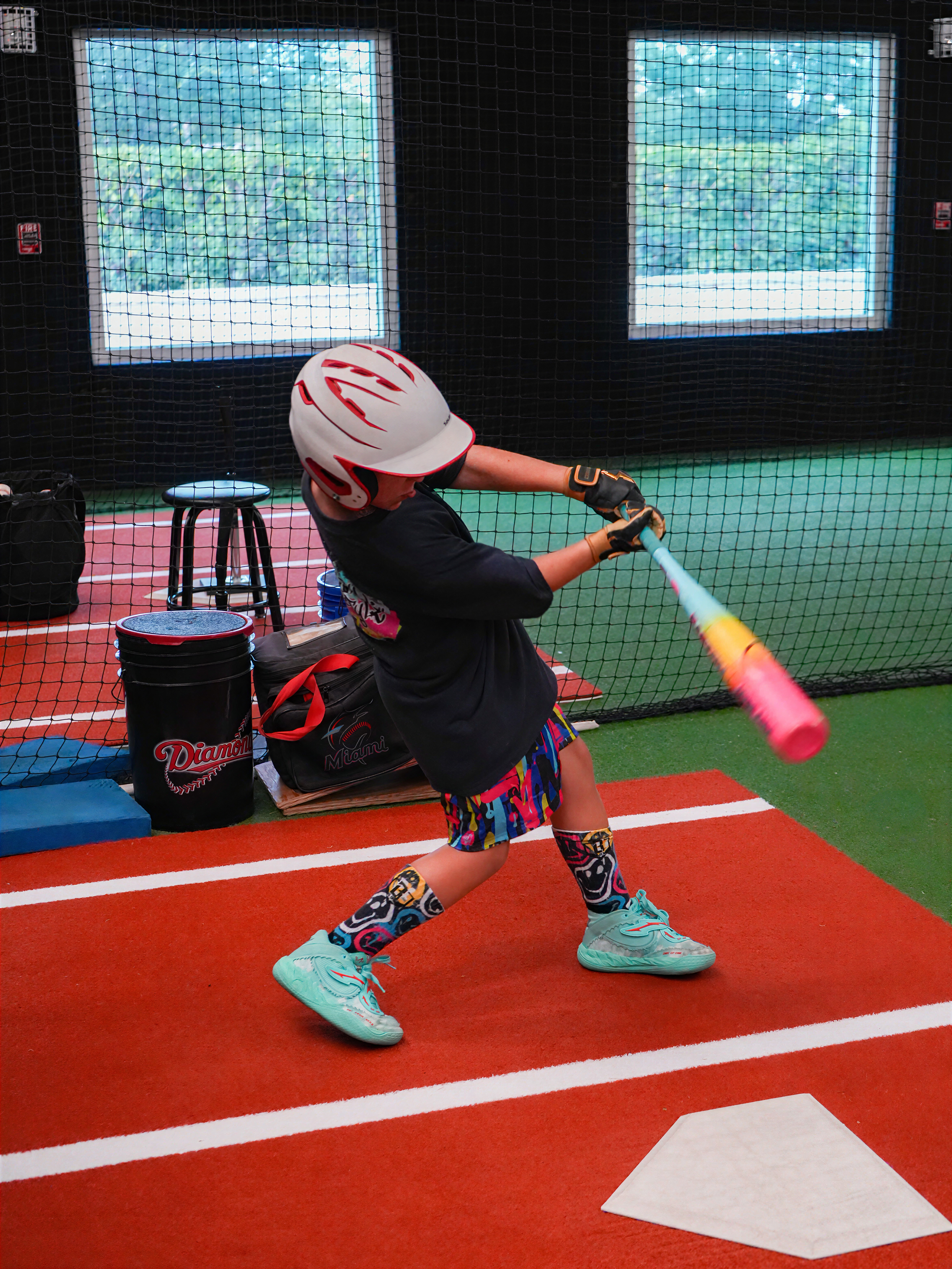 Youth baseball player swinging during a one-on-one hitting lesson at XLB Training in Boynton Beach, Florida