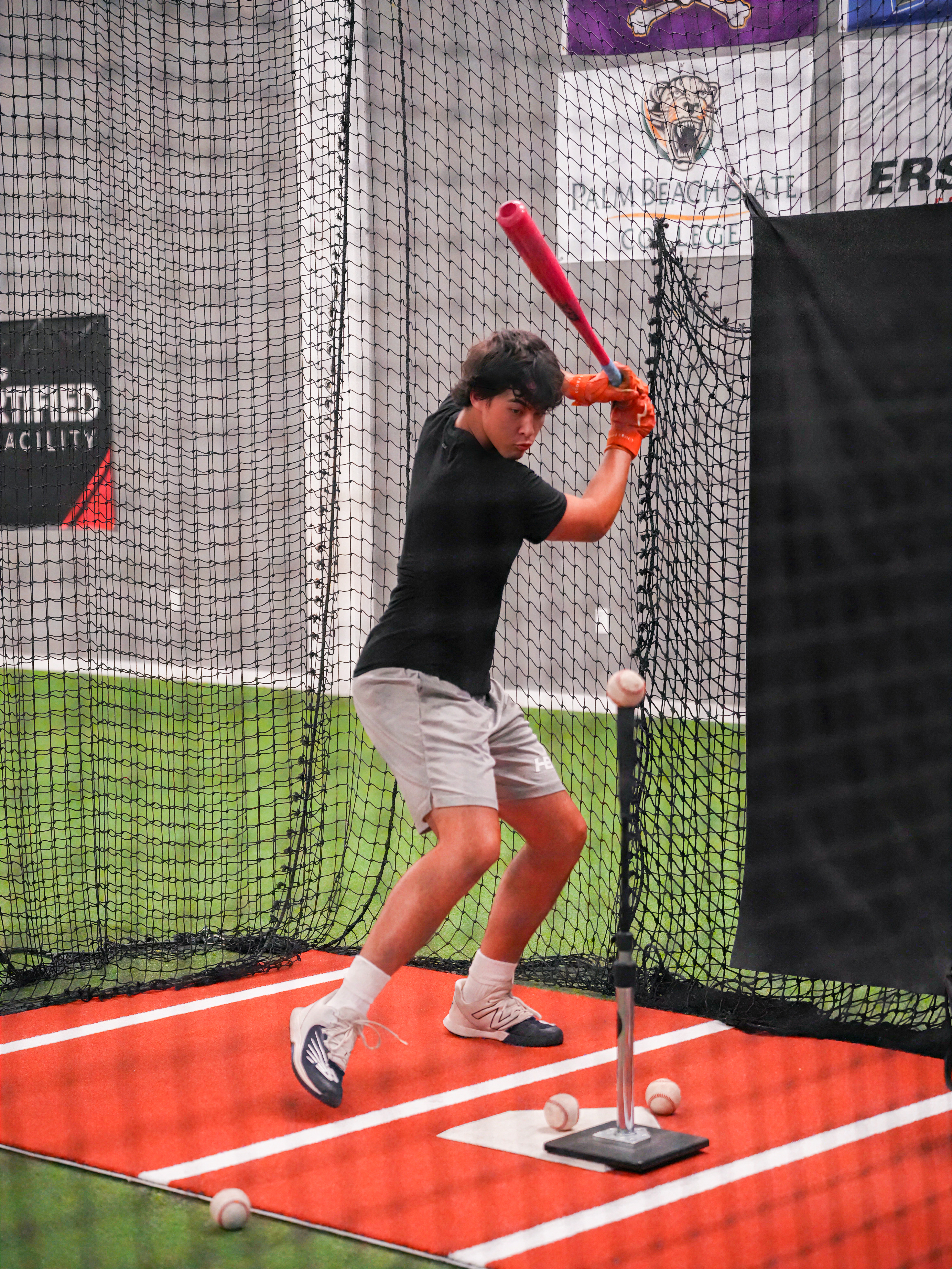 High school baseball player working through tee reps during a hitting session at XLB Training