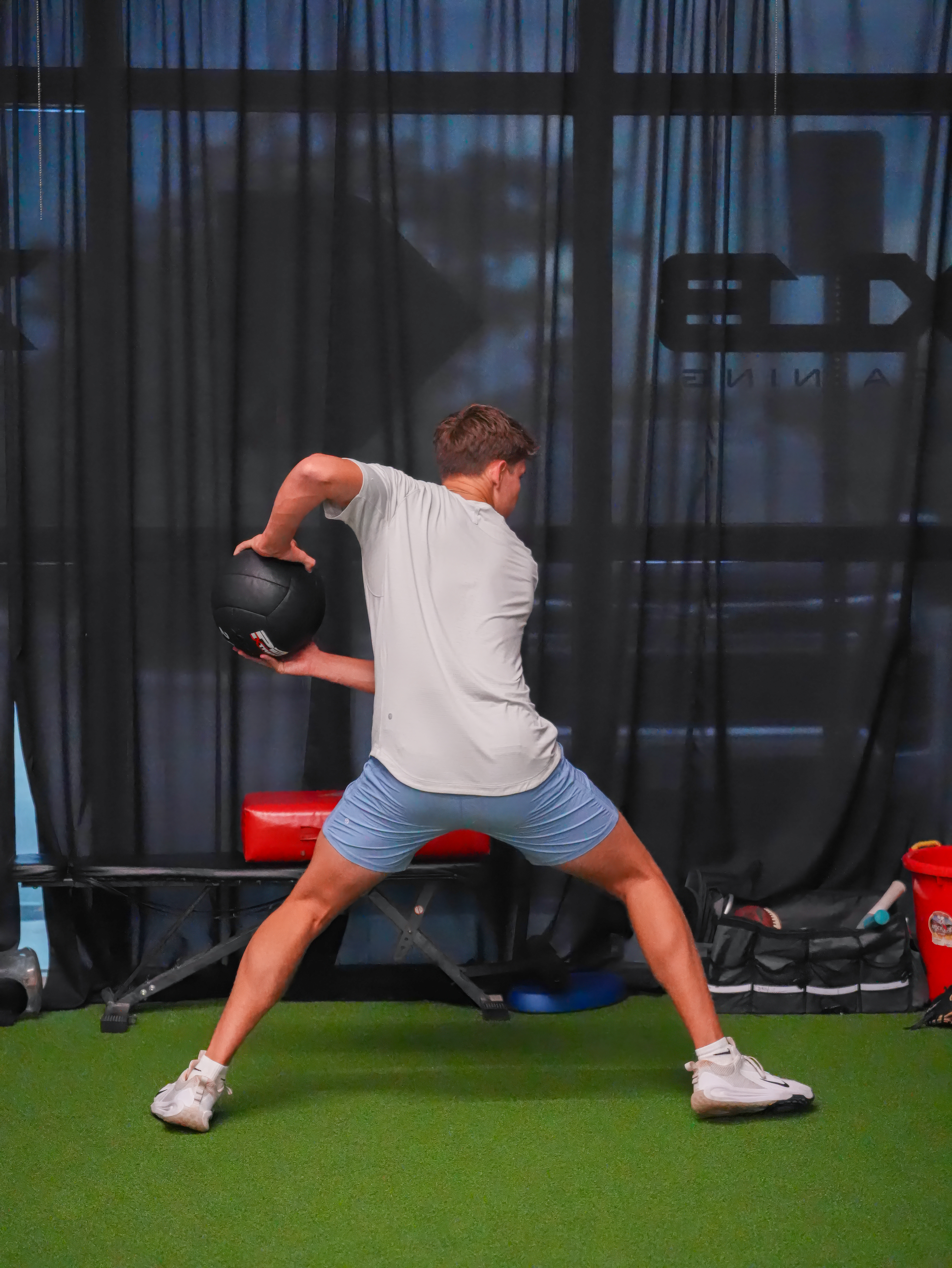 Baseball player performing rotational medicine ball work in XLB Training's strength and performance program