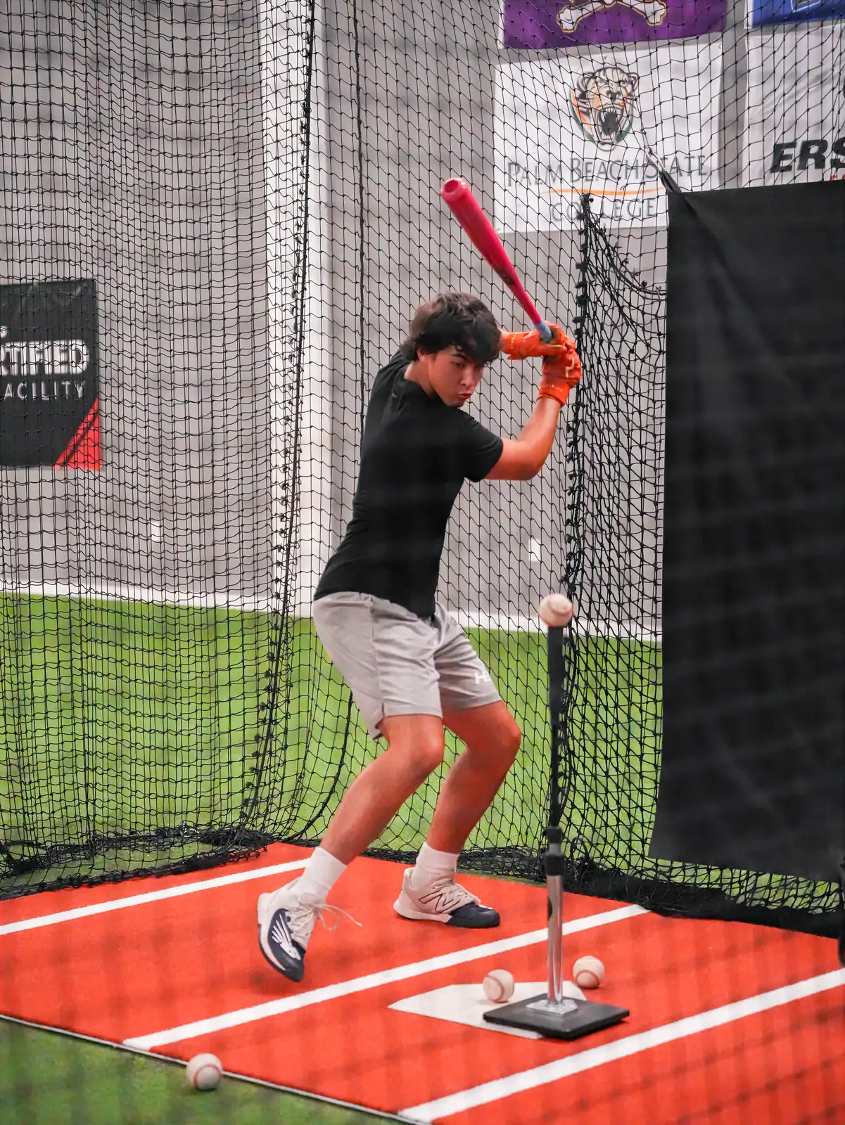 High school baseball player working through tee reps during a hitting session at XLB Training
