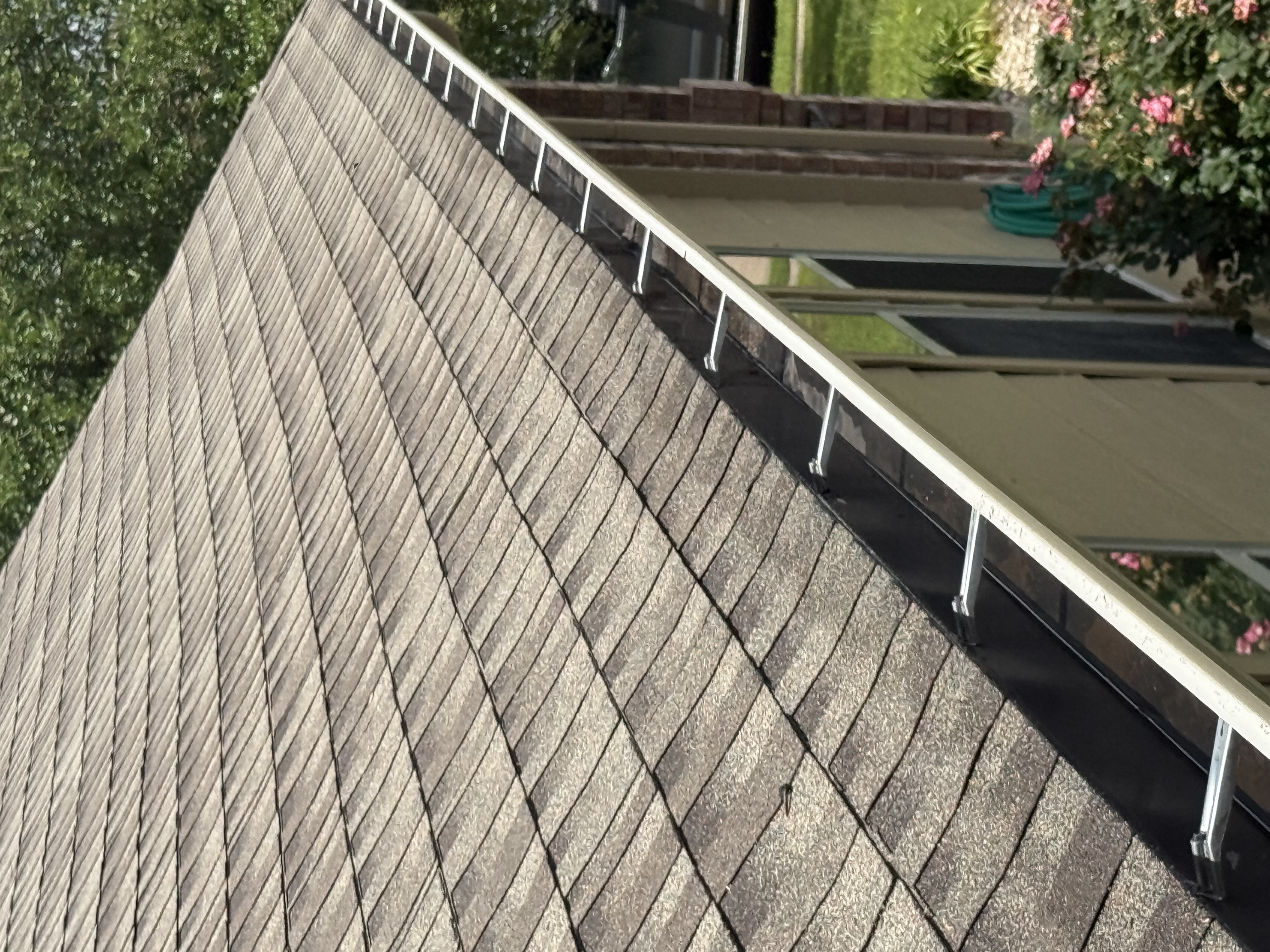 Clean, debris-free gutters along a shingle roofline