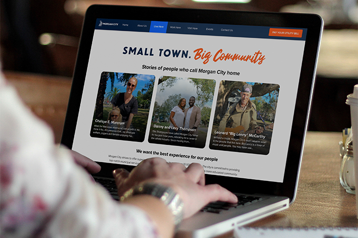 Morgan City website on a laptop screen showing the Big Community variation in the Live Here section with resident stories