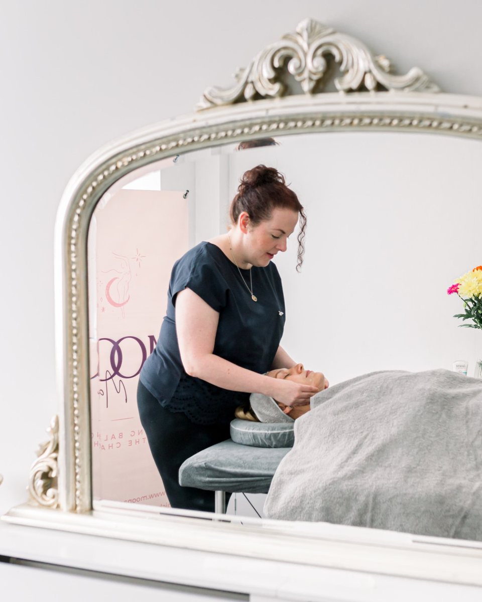 Michelle giving a treatment, seen in a mirror