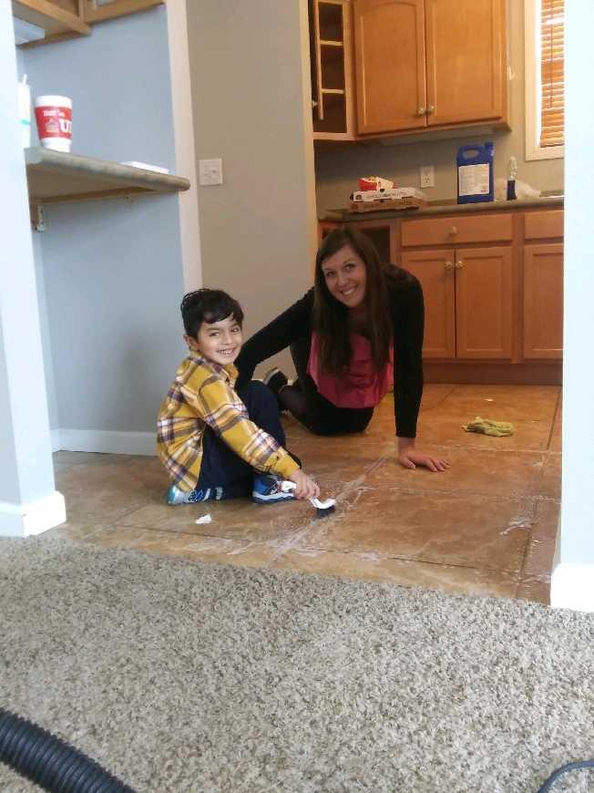 Golden Rule Cleaning owner cleaning tile floors alongside a young helper in St. Charles MO