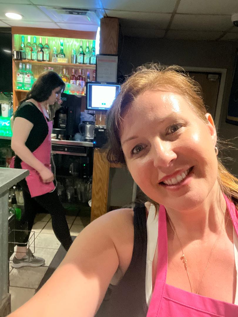 Golden Rule Cleaning owner Sarah and team member in pink aprons cleaning a commercial bar in St. Charles MO