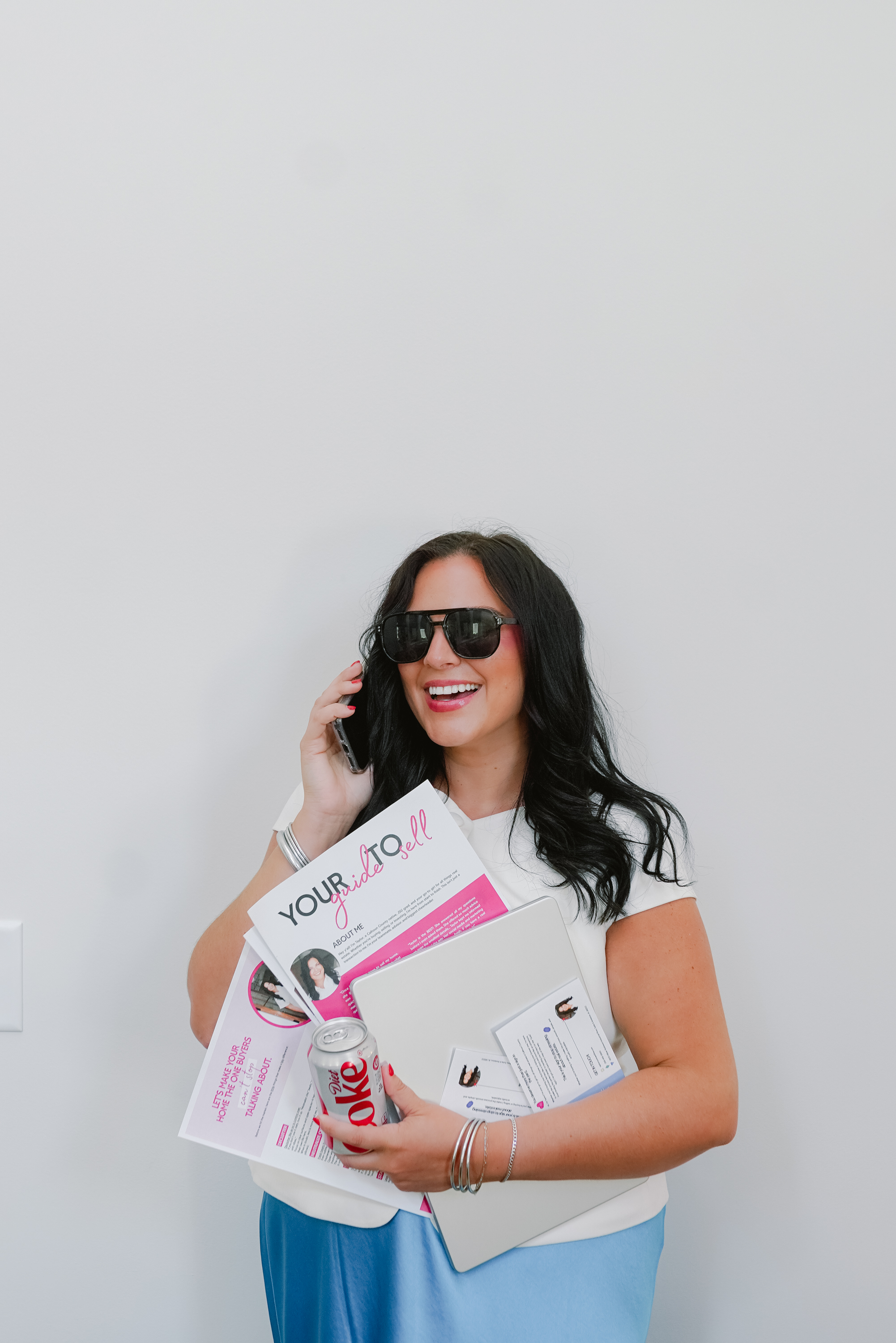 Taylor McAllister real estate agent holding a bunch of papers and phone Taylor McAllister real estate agent holding a bunch of papers and phone