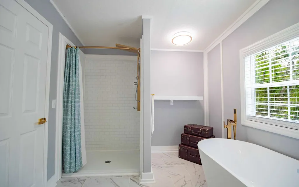 Bathroom at 1103 NW Moore Road with a tiled walk-in shower and a freestanding tub