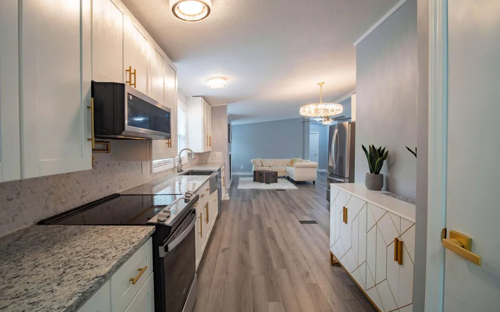 Kitchen at 1103 NW Moore Road with granite counters, white soft-close cabinetry and new stainless appliances