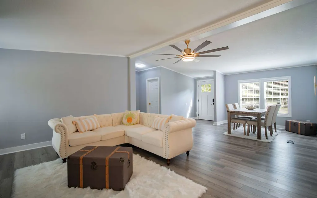 Living room at 1103 NW Moore Road with luxury vinyl plank flooring, looking through to the dining area and the front door