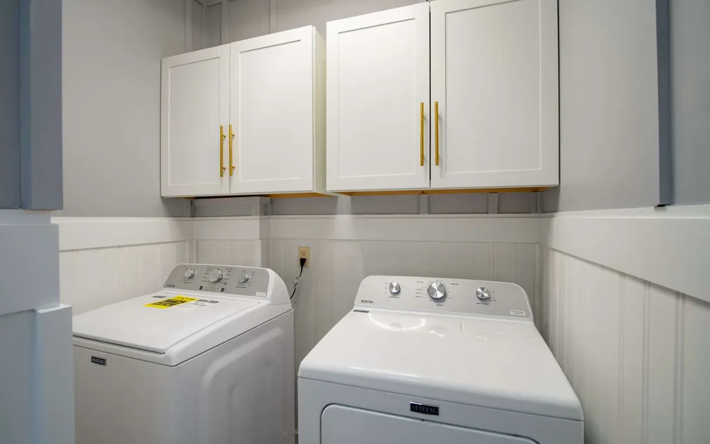 Laundry room at 1103 NW Moore Road with a washer, a dryer and cabinets above