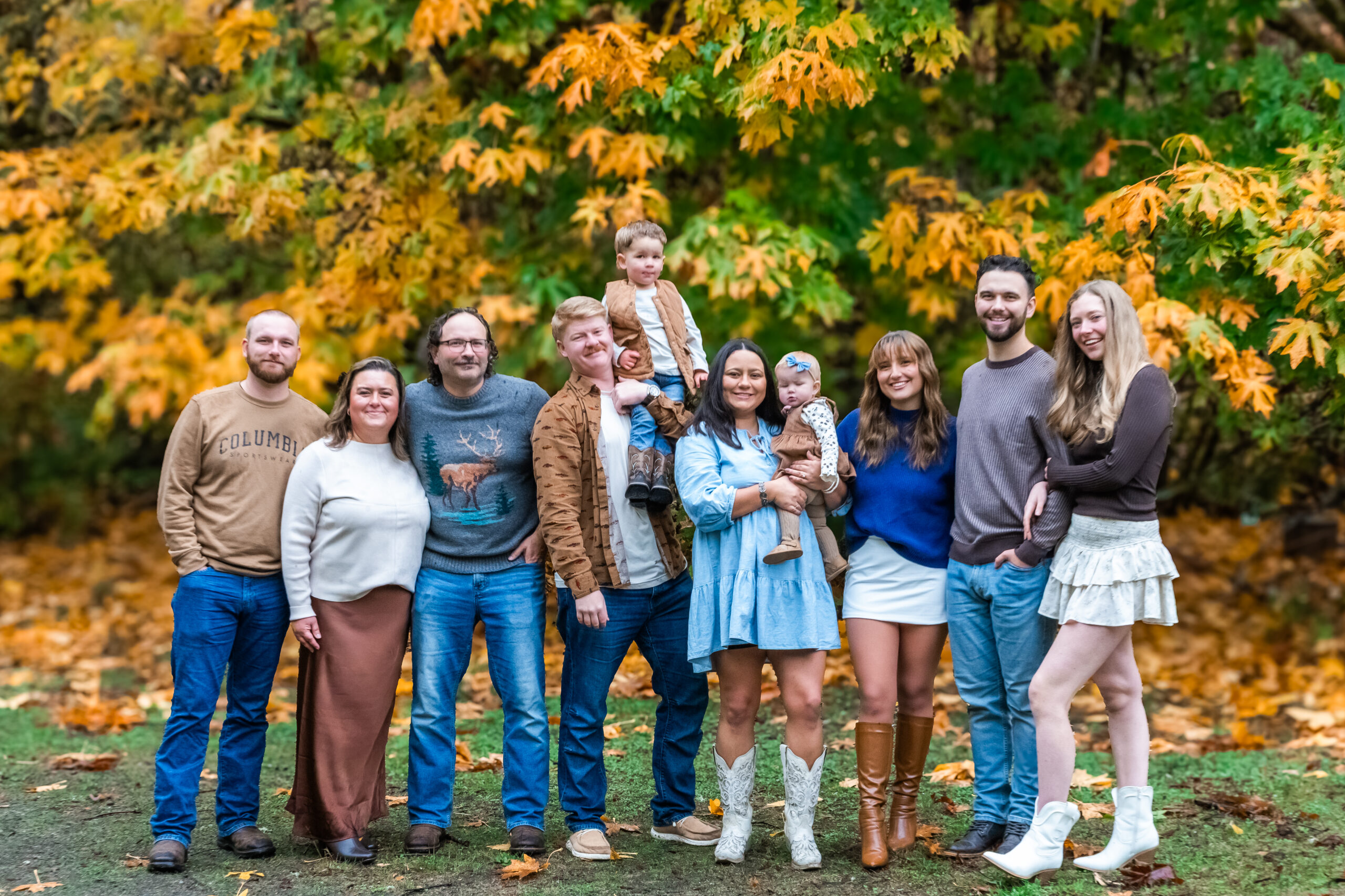 Family posing with fall leaves at Manchester State Park in Kitsap County