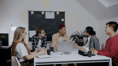 Aligned team in an active working session — strategy on the board, everyone engaged, ideas flowing