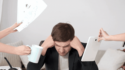 Overwhelmed founder surrounded by demands — papers, coffee, devices being thrust at him from all sides