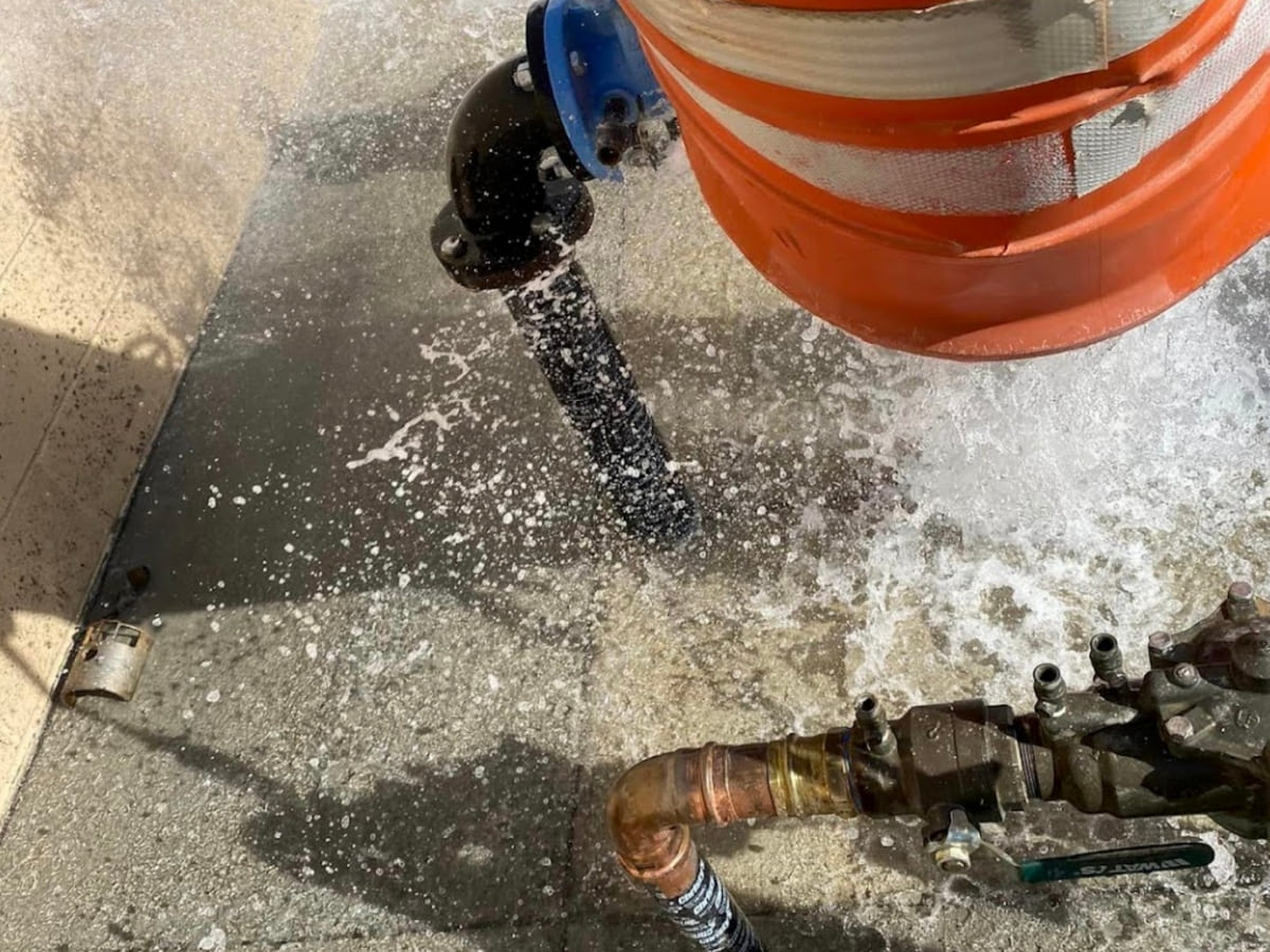 A backflow prevention device undergoing a test, showing water pressure spraying out during the backflow test to ensure proper function.