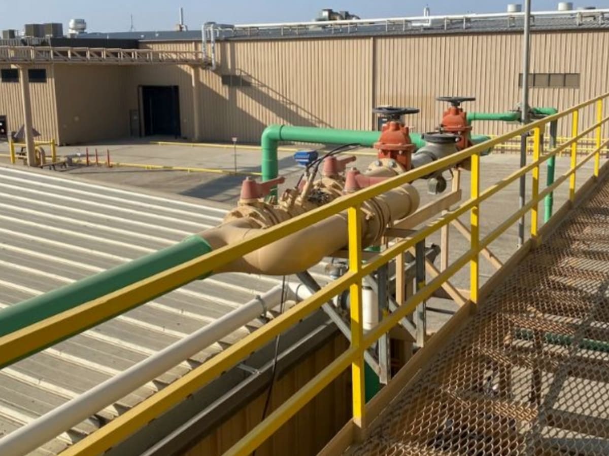 A backflow prevention device installed on an elevated platform in an industrial facility, showing large-scale water system management and protection from contamination.