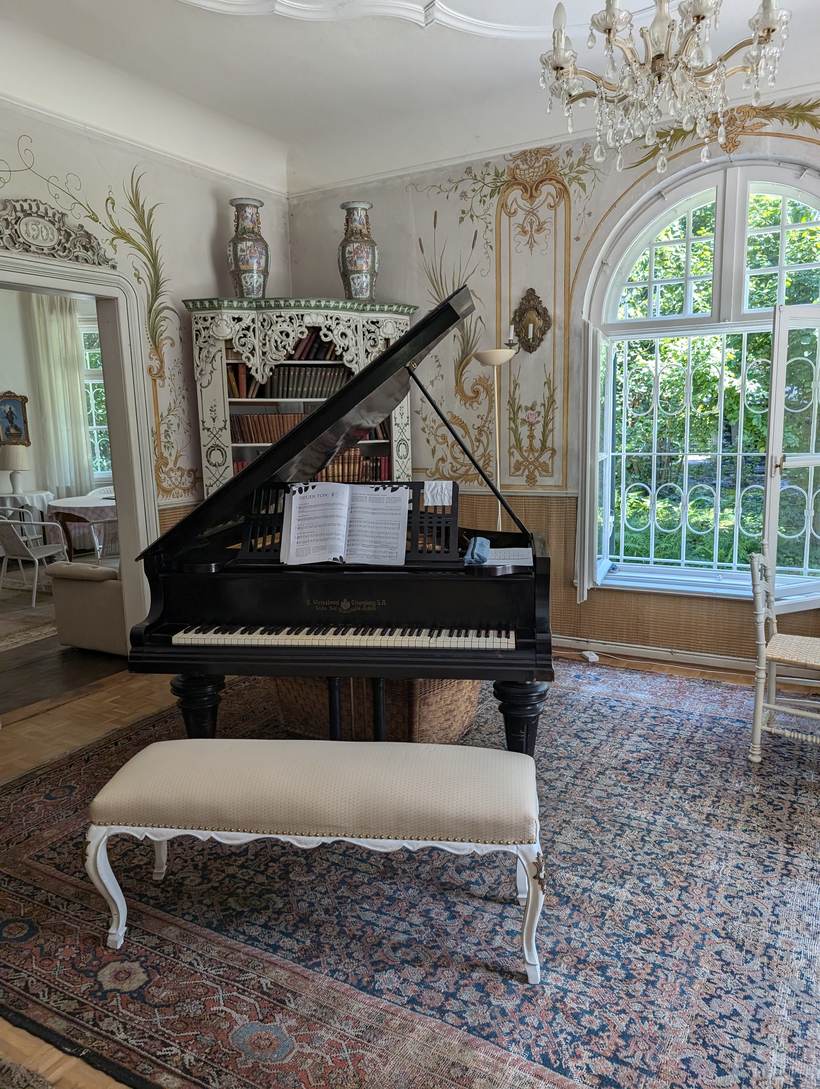The grand piano beneath the arched window