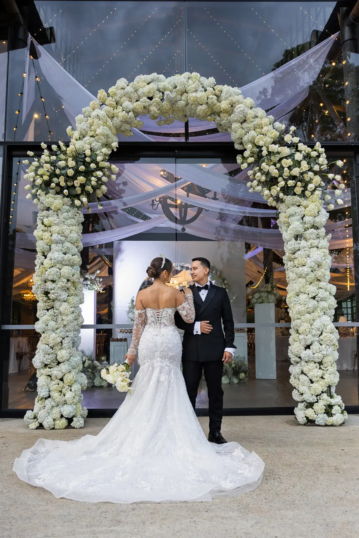 Camila y Jonatan bajo el arco floral