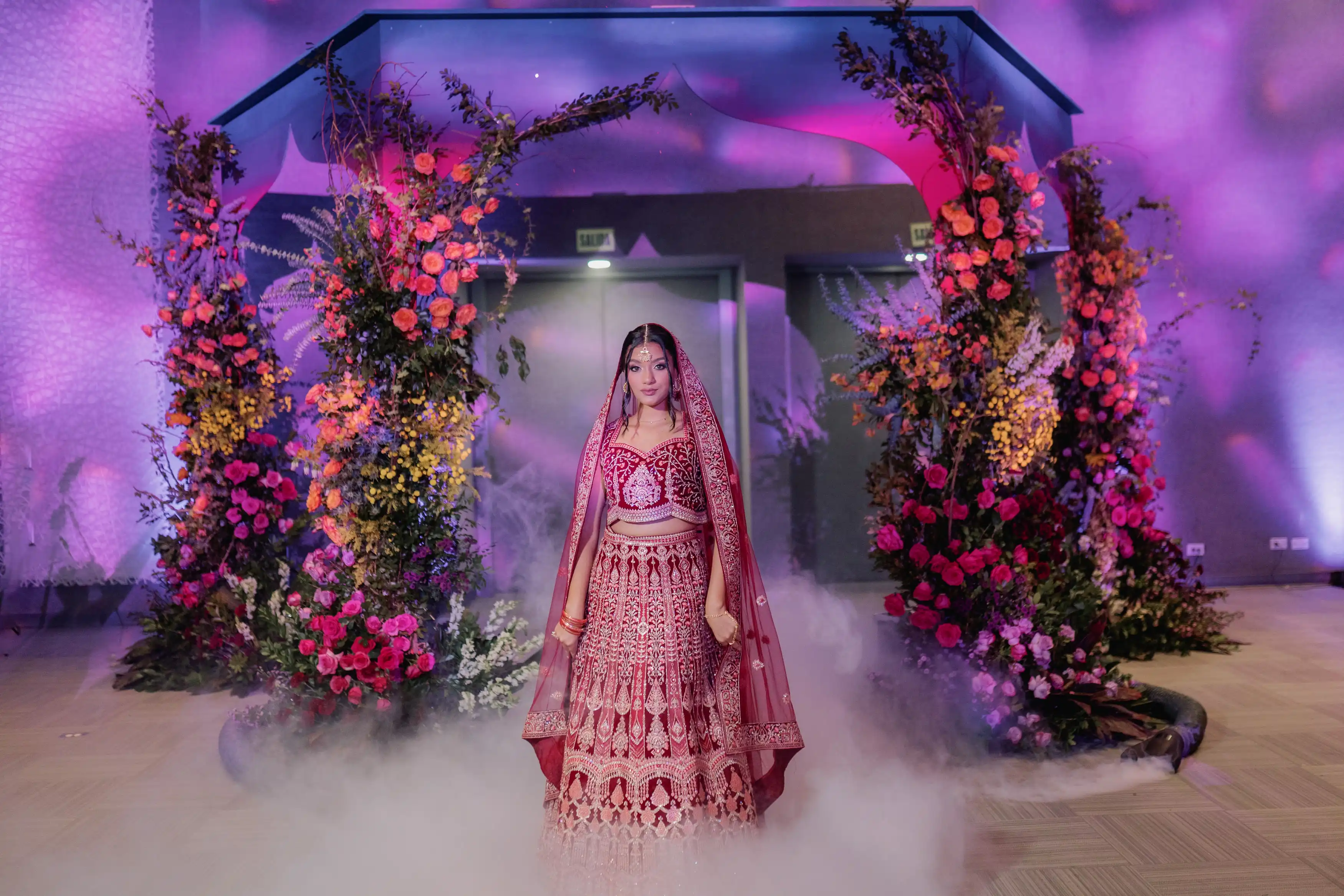 Novia bajo un arco floral fucsia