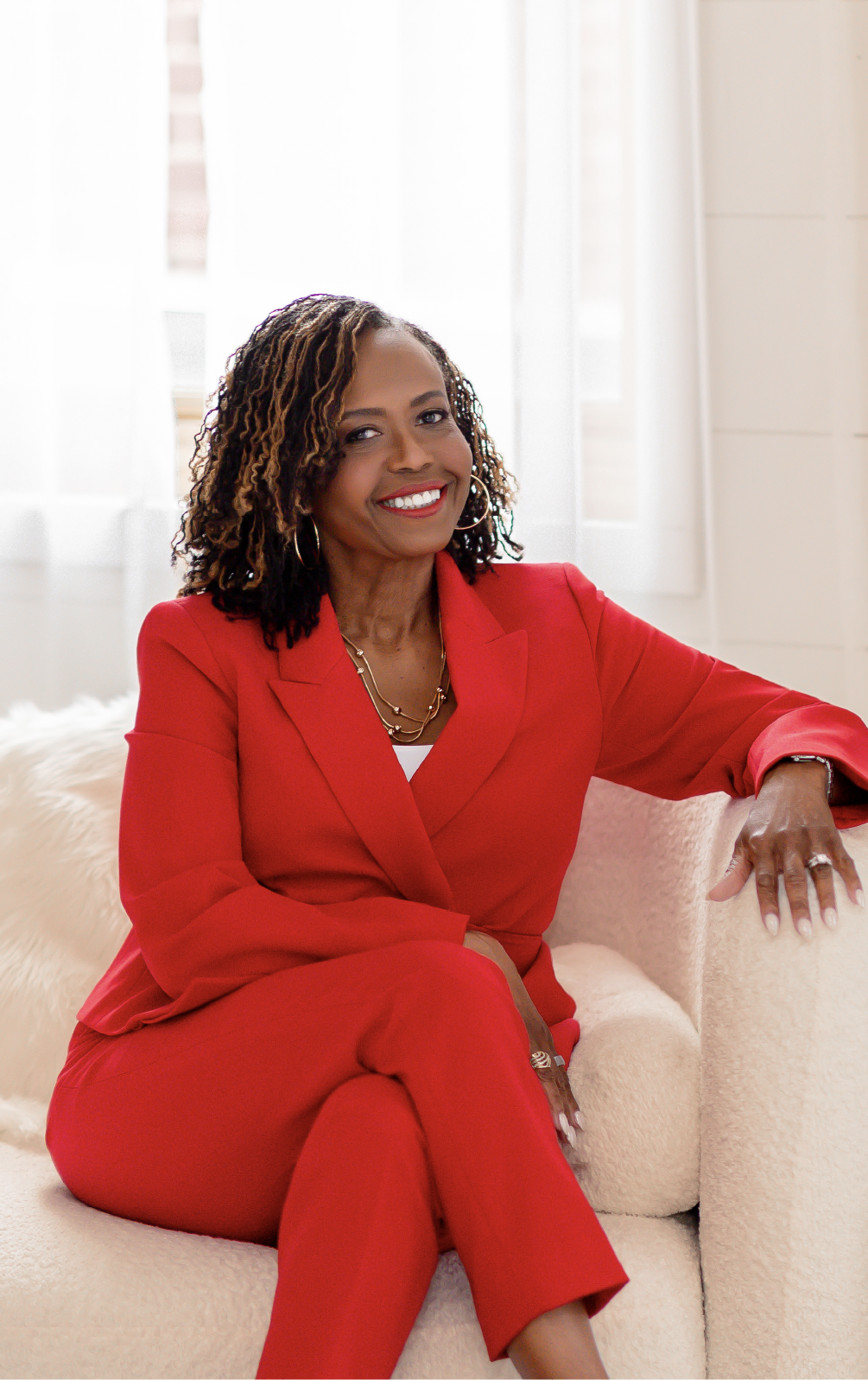 Glynnis Day Thatch, NP, seated in a red suit.